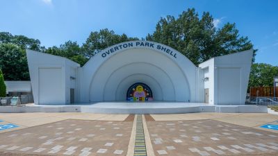 Front view of the iconic open-air Overton Park Shell amphitheater stage under a bright blue sky in Midtown Memphis