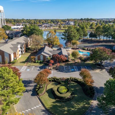 Aerial view of Southcrest apartments near Memphis in North Mississippi DeSoto County, featuring a pool, tennis courts, pond, and landscaped roundabout entrance