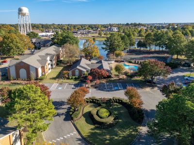 Aerial view of Southcrest apartments near Memphis in North Mississippi DeSoto County, featuring a pool, tennis courts, pond, and landscaped roundabout entrance