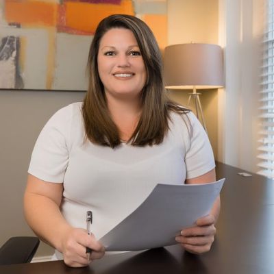 Smiling female property manager reviewing documents at a desk inside a Memphis apartments leasing office