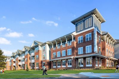 Street-corner exterior view of The Park Memphis apartments, a four-story brick and siding building with covered balconies and a distinctive corner tower