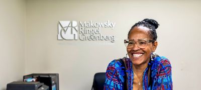 Smiling Makowsky Ringel Greenberg team member at the front desk of a Memphis apartments management company office