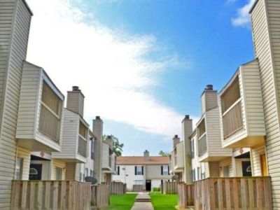 Two-story residential buildings with private patios and a central walkway at Annie's Townhomes and Apartments in Memphis.