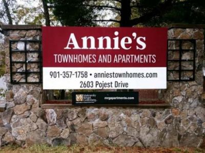 Stone monument community entrance sign for Annie's Townhomes and Apartments in Memphis, showcasing property details.