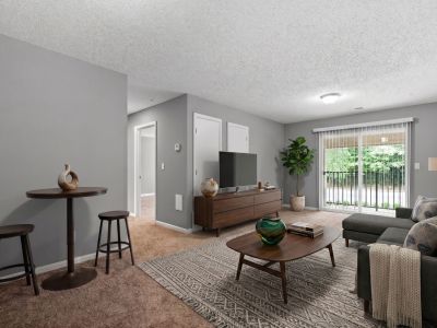 Virtually staged living room layout with a grey sectional, a wooden media console, and a sliding glass patio door at Annie's Townhomes and Apartments in Memphis.