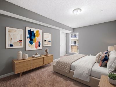 Virtually staged primary bedroom highlighting an upholstered bed, contemporary abstract artwork, and a light wood dresser at Annie's Townhomes and Apartments in Memphis.