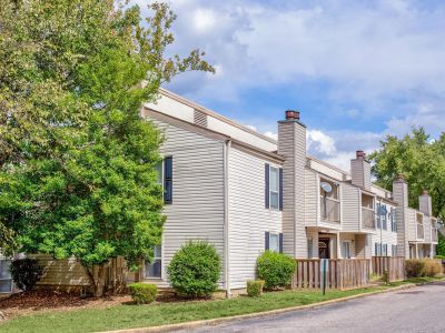 Beige residential buildings with black shutters and manicured lawns at Annie's Townhomes and Apartments in Memphis.