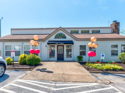 Front exterior of the leasing office with large windows and balloon decor at Annie's Townhomes and Apartments in Memphis.