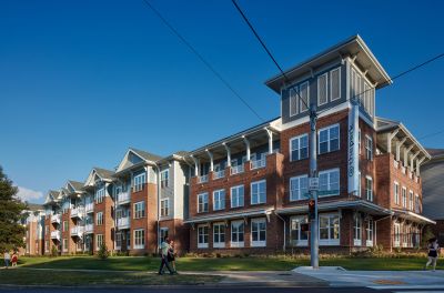 Street-corner exterior view of The Park Memphis apartments, a four-story brick and siding building with covered balconies and a distinctive corner tower