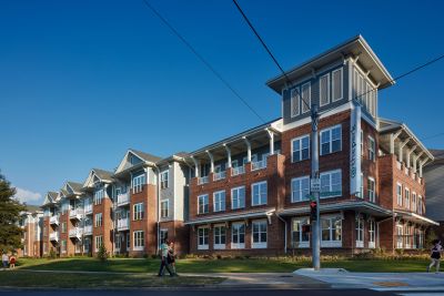 Street-corner exterior view of The Park Memphis apartments, a four-story brick and siding building with covered balconies and a distinctive corner tower