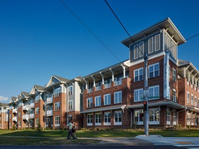 Street-corner exterior view of The Park Memphis apartments, a four-story brick and siding building with covered balconies and a distinctive corner tower