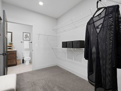 Spacious walk-in closet with wire shelving and hanging rod adjacent to a full bathroom in a Memphis apartments unit at The Park