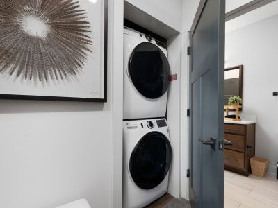 In-unit stacked washer and dryer in a hallway closet of a Memphis apartments unit at The Park, adjacent to a full bathroom