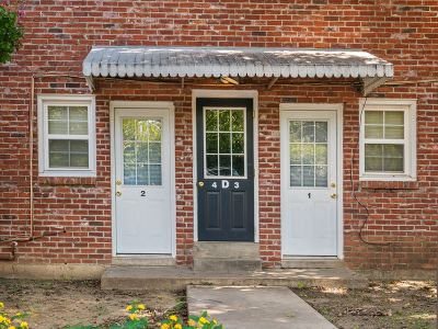 Private entry doors under a white awning on a red brick building at Audubon Downs apartments in Memphis.
