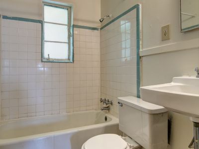 Classic tiled bathroom with a white bathtub and pedestal sink at Audubon Downs apartments in Memphis.