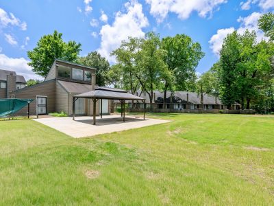 Spacious courtyard green lawn featuring an outdoor gazebo structure on a concrete pad at The Birches Townhomes in South Memphis.