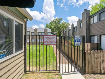 Gated resident entrance path showcasing community guidelines and neighborhood watch signage at The Birches Townhomes in South Memphis.