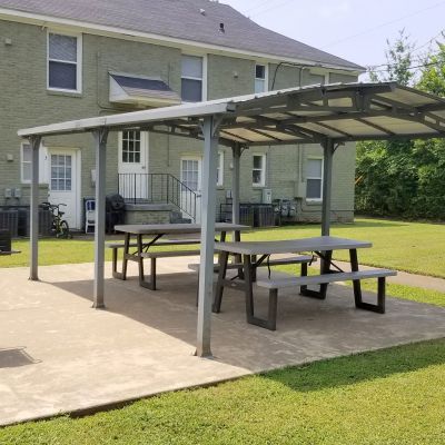Covered outdoor picnic pavilion with tables and charcoal grills at Bluff City Apartments in Memphis.