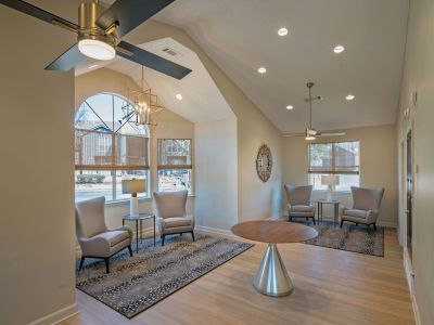 Cozy resident lounge area inside the community clubhouse with elegant wingback chairs and stylish accent decor at Champion Hills apartments in Memphis.