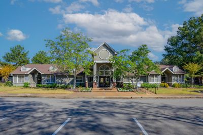 Exterior front view of the leasing office and clubhouse building with manicured landscaping at Champion Hills apartments in Memphis.