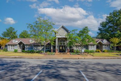 Exterior front view of the leasing office and clubhouse building with manicured landscaping at Champion Hills apartments in Memphis.