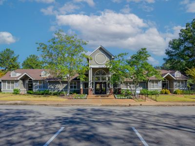 Exterior front view of the leasing office and clubhouse building with manicured landscaping at Champion Hills apartments in Memphis.