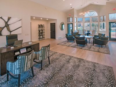 Spacious leasing office and clubhouse lobby featuring a reception desk and comfortable modern seating areas at Champion Hills apartments in Memphis.