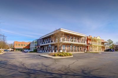 Exterior street view of mixed-use retail and residential buildings with second-story balconies at the Lofts in Town Square loft apartments in Southaven.