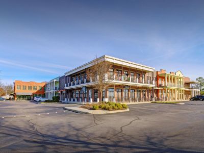 Exterior street view of mixed-use retail and residential buildings with second-story balconies at the Lofts in Town Square loft apartments in Southaven.
