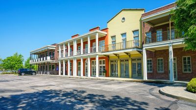 Vibrant mixed-use community buildings featuring colorful storefront facades and residential balconies above a parking area at the Lofts in Town Square loft apartments in Southaven.