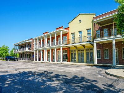 Vibrant mixed-use community buildings featuring colorful storefront facades and residential balconies above a parking area at the Lofts in Town Square loft apartments in Southaven.
