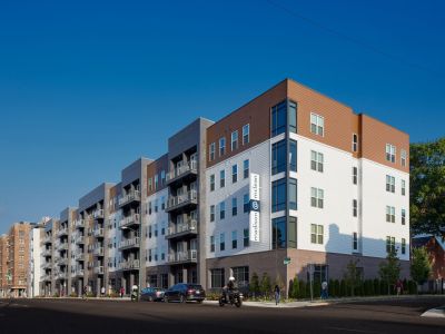 Exterior street corner view of the modern Madison@McLean mid-rise building featuring private balconies and contemporary architecture in Midtown apartments, Memphis.
