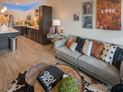 Open-concept apartment floor plan showcasing the kitchen island leading directly into the styled living room space at Madison@McLean Midtown apartments in Memphis.