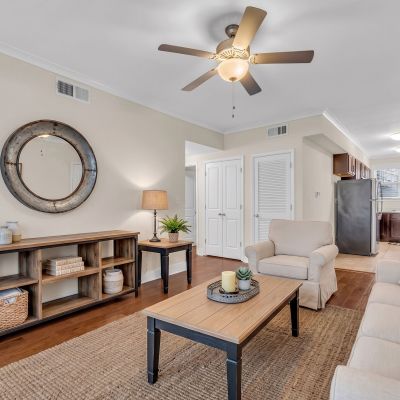 Beautifully renovated open-concept living area with dark hardwood floors leading into a modern kitchen at Stratford Place apartments in Memphis.