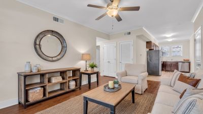 Beautifully renovated open-concept living area with dark hardwood floors leading into a modern kitchen at Stratford Place apartments in Memphis.