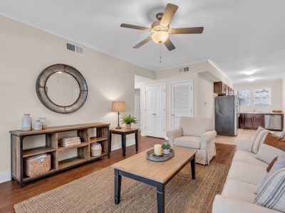 Beautifully renovated open-concept living area with dark hardwood floors leading into a modern kitchen at Stratford Place apartments in Memphis.