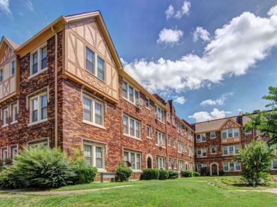 Exterior courtyard view of the historic brick residential building featuring classic half-timbered gables at Midtown Place The Tuscany apartments in Memphis.