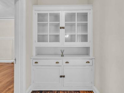 Original built-in white vintage dining hutch with glass cabinet doors and storage drawers unique to the Park Lane apartment layouts at Midtown Place in Memphis.