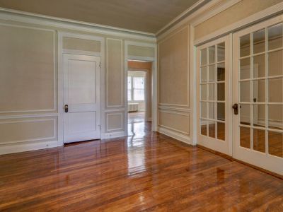apartment interior room highlighting glossy hardwood floors, elegant wall trim, and glass doors inside Park Lane residence at Midtown Place in Memphis.