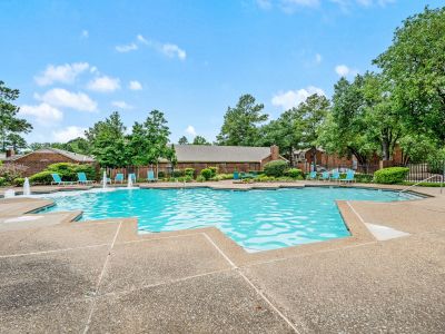 Large outdoor community swimming pool lined with turquoise lounge chairs at Monticello apartments in Memphis.