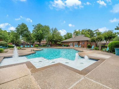 Sparkling outdoor swimming pool with water fountains on a sunny day at Monticello apartments in Memphis.