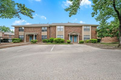 Two-story brick apartment buildings with individual columned entrance porches at Monticello apartments in Memphis.