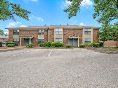 Two-story brick apartment buildings with individual columned entrance porches at Monticello apartments in Memphis.