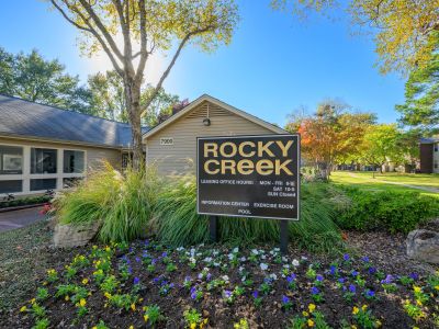Community monument entrance sign for Rocky Creek Apartments in Southaven, Mississippi, surrounded by seasonal flower beds