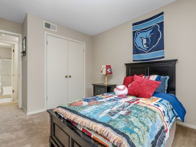 Sports-themed bedroom featuring a Grizzlies basketball wall banner and a dark wood bed frame at Rocky Creek Apartments in Southaven, Mississippi.