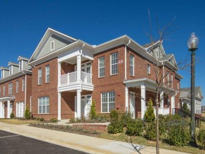 Modern two-story brick residential buildings featuring private balconies and white pillars at The Signature at Schilling Farms apartments in Collierville.