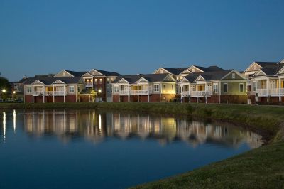 Scenic evening view of community apartments reflecting onto a peaceful neighborhood lake at The Signature at Schilling Farms apartments in Collierville