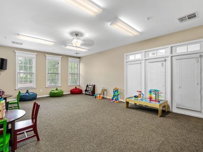 Spacious indoor community playroom filled with kids' toys, activity tables, and bean bag chairs at The Signature at Schilling Farms apartments in Collierville.