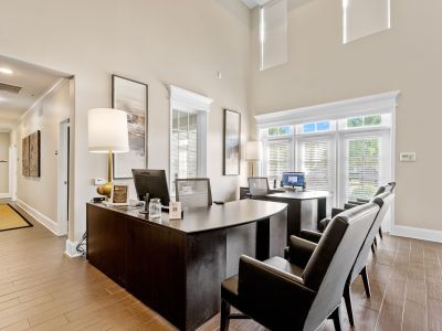 Bright leasing office reception desk with high ceilings and large windows at The Signature at Schilling Farms apartments in Collierville near Memphis.
