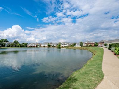 Scenic community lake with a paved walking trail and grassy banks at The Signature at Schilling Farms apartments in Collierville near Memphis.